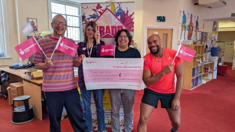 Members of the Trade team hold up a large cheque with the funding they received for Trans*Thriving project equalling £267,520