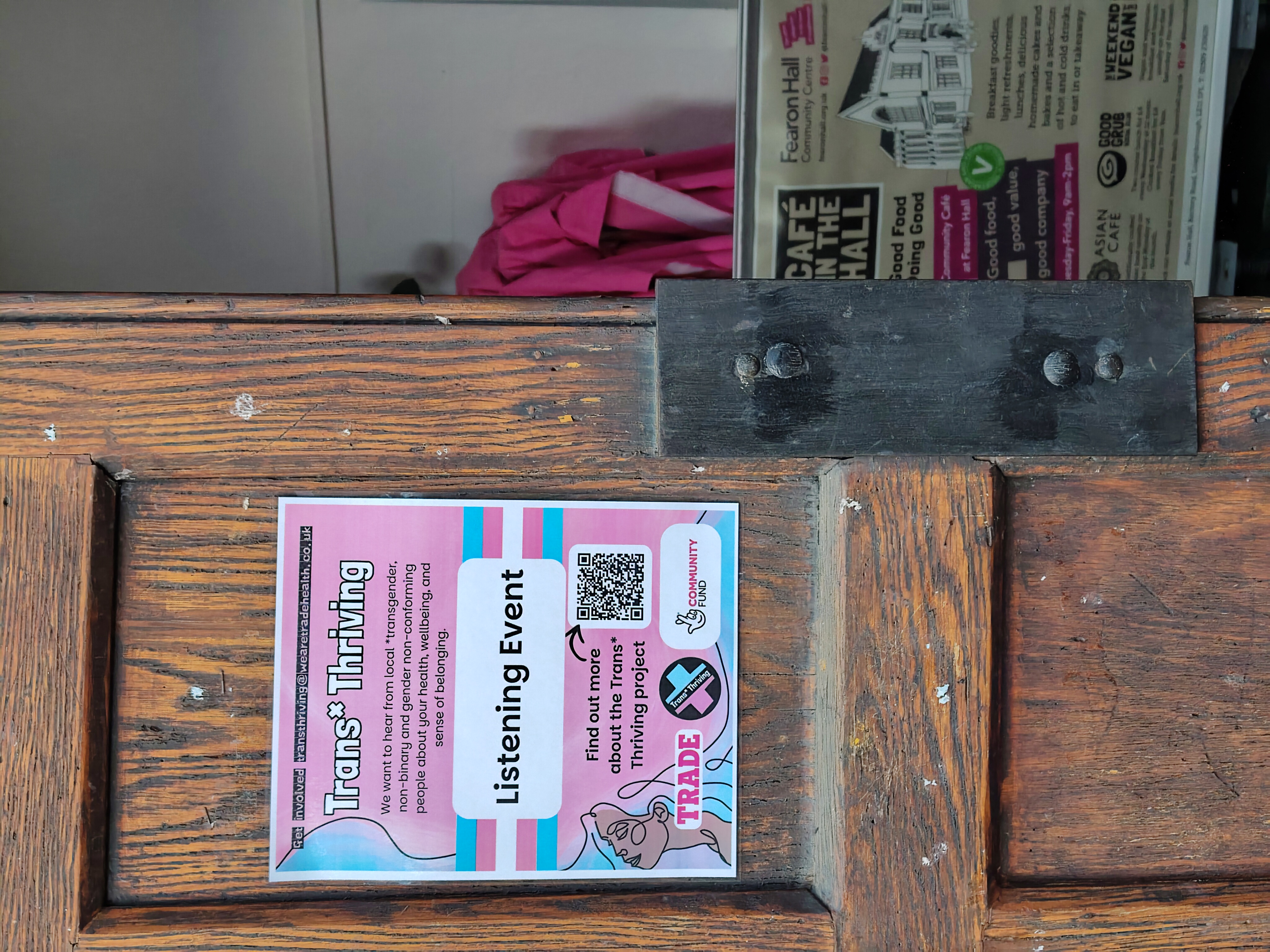 A poster for a Trans*Thriving listening event advertised on a venue door.